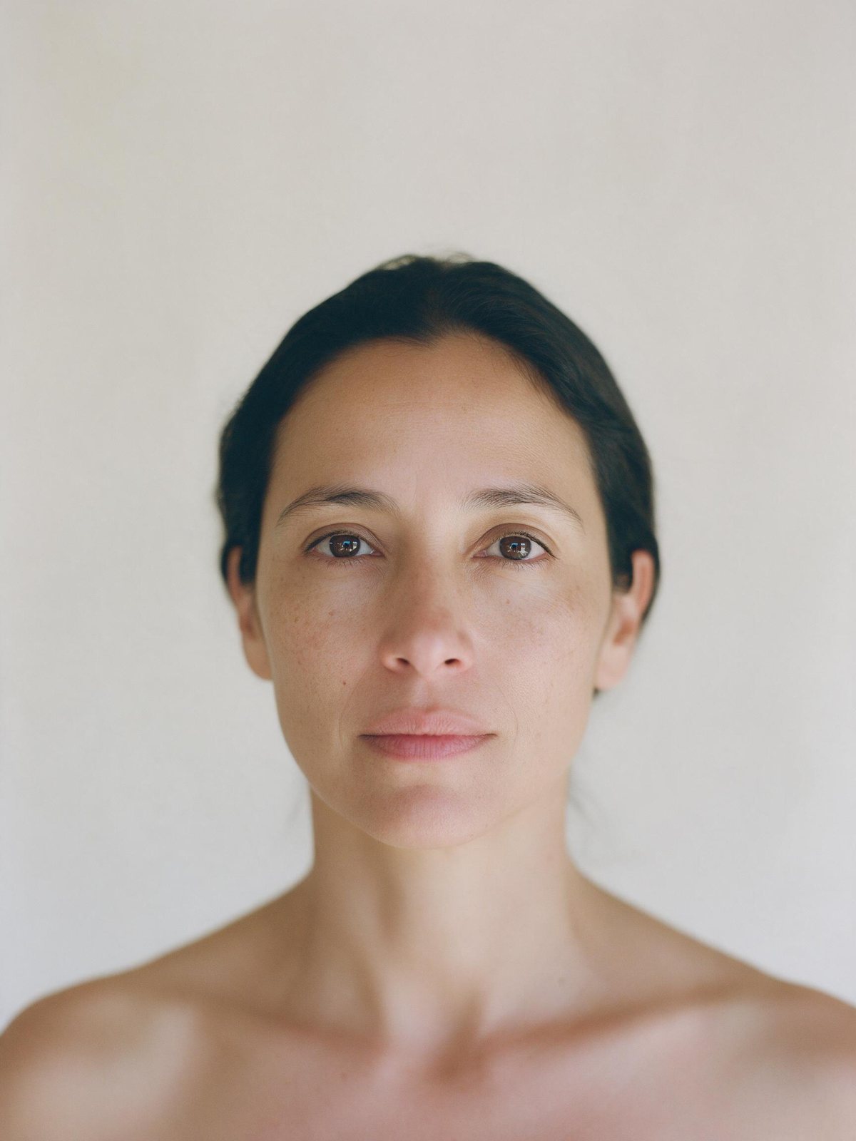 Retrato frontal de una mujer adulta sin maquillaje; a la derecha del comparador, las zonas del rostro marcadas sobre su propia foto.